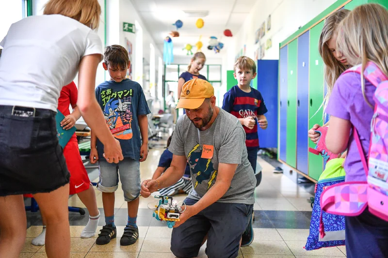 Kinder führen LEGO Roboter im Flur vor